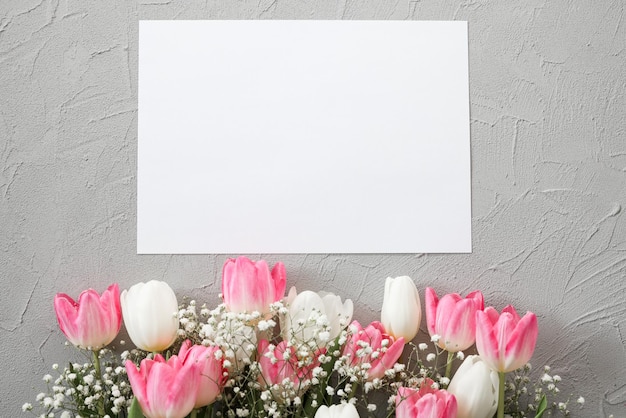 Ramo de tulipanes rosas y flores blancas de gypsophila sobre un elegante fondo de piedra gris Concepto de celebración de cumpleaños del Día de la Madre Copiar espacio para texto Mockup