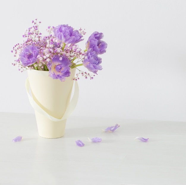 Ramo de tulipanes rosas y gypsophila sobre mesa blanca