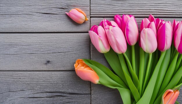 Un ramo de tulipanes rosas sobre una mesa de madera