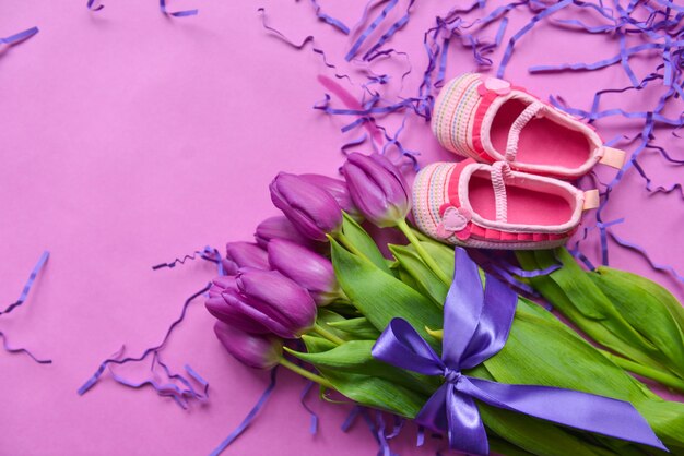 Foto ramo de tulipanes y zapatos infantiles para niñas.