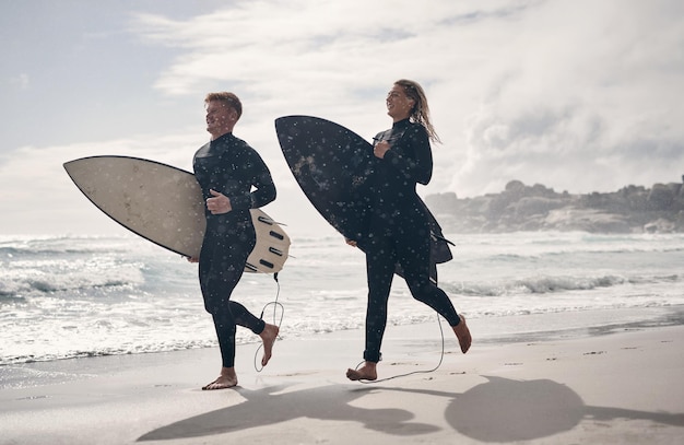 Éramos adictos a las prisas Foto de una pareja joven surfeando juntos en la playa