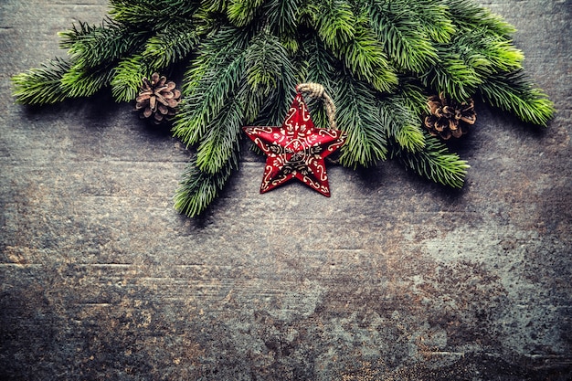 Ramos de abeto de estrela de Natal e cones no quadro escuro.