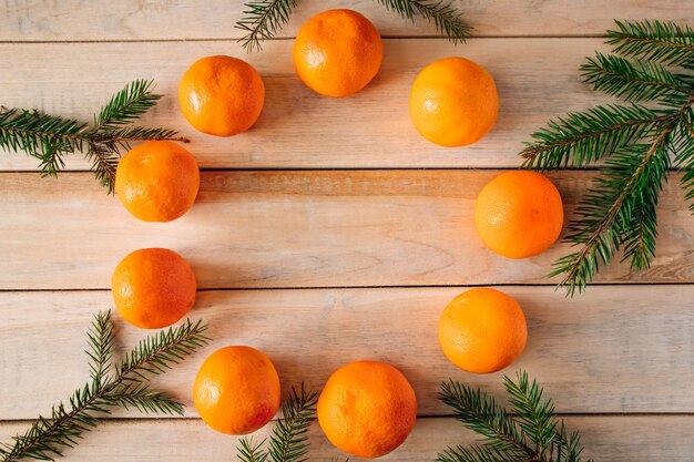 Ramos de abeto e tangerinas em madeira