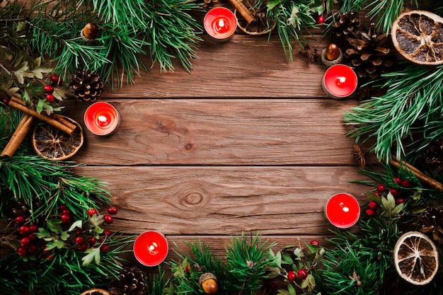 Ramos de Natal com velas na mesa de madeira