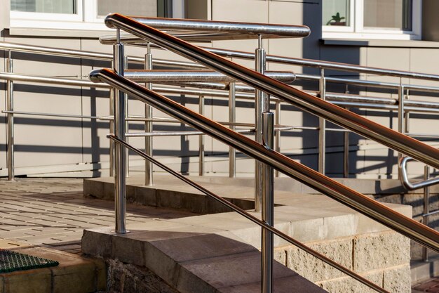 Una rampa y barandillas metálicas en la entrada del edificio residencial para comodidad de las personas con discapacidad y de la tercera edad