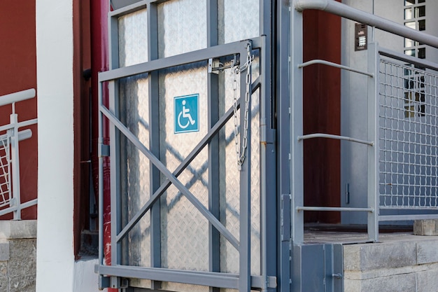 Rampa para cadeiras de rodas com elevador na entrada de um prédio residencial.