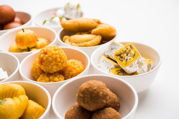 Rangoli mit verschiedenen indischen Süßigkeiten oder Mithai in einer Schüssel für Diwali oder andere Feste, selektiver Fokus