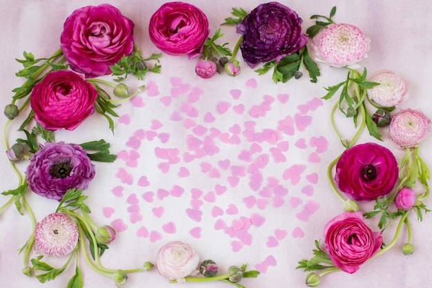 Un ranúnculo con flores y corazones rosados dentro.