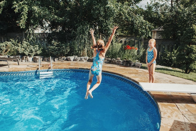 Rapariga a saltar na piscina contra as árvores