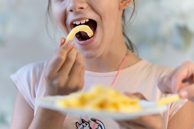 rapariga asiática feliz comer batatas fritas e desfrutar muito comida não saudável faz as pessoas felizes conflitos