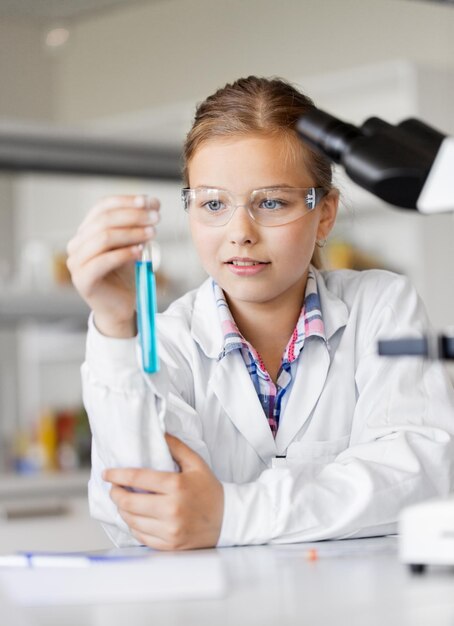 Foto rapariga com tubo de ensaio a estudar química na escola