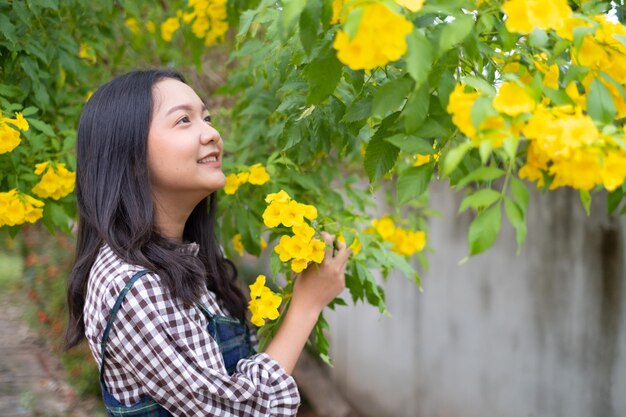 Rapariga do retrato com menina asiática das flores amarelas