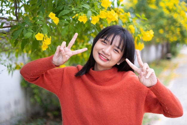 Rapariga do retrato com menina asiática das flores amarelas