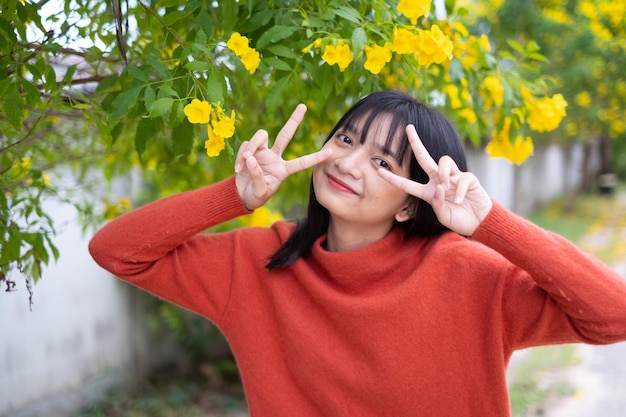 Rapariga do retrato com menina asiática das flores amarelas