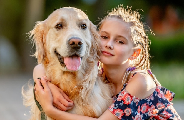 Rapariga pré-adolescente com cão golden retriever