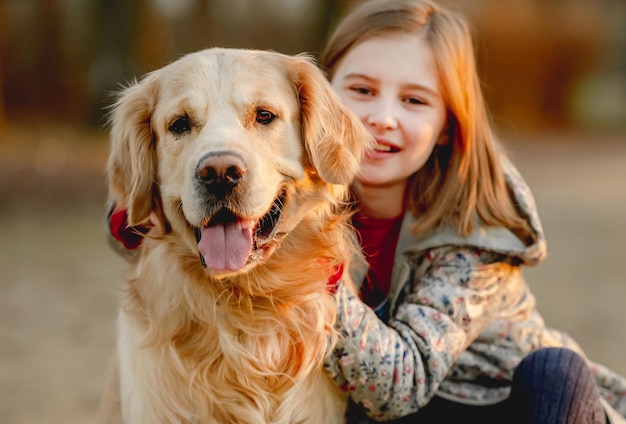 Rapariga pré-adolescente com cão golden retriever