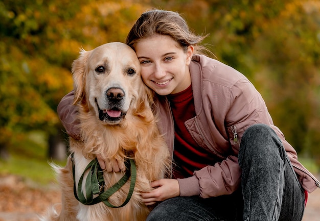 Rapariga pré-adolescente com cão golden retriever