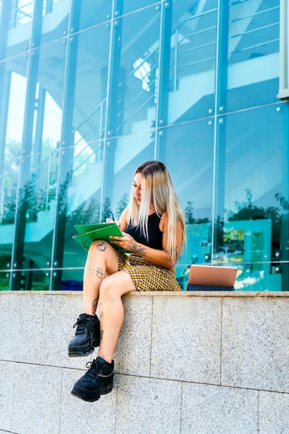 Rapariga universitária LGTBI Moderna garota tatuada sentada estudando na faculdade de filosofia