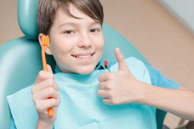 Rapaz adolescente fazendo tratamento odontológico no consultório do dentista Conceito de atendimento odontológico de dentes saudáveis