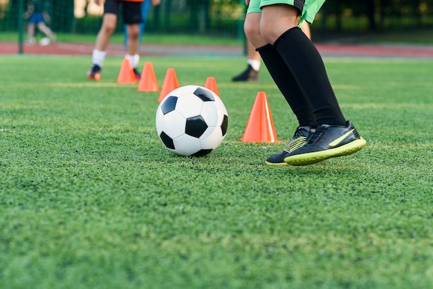 Rapaz adolescente jogando futebol no campo de futebol