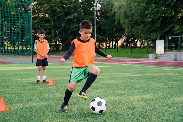 Rapaz adolescente jogando futebol no campo de futebol