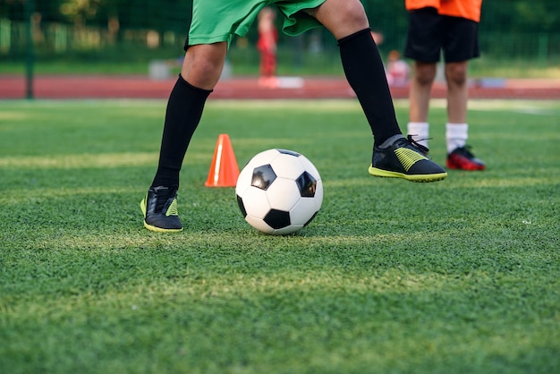 Rapaz adolescente jogando futebol no campo de futebol