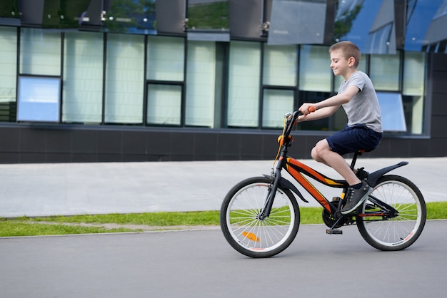 Rapaz anda de bicicleta sozinho na rua