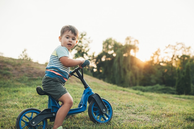 Rapaz, andar de bicicleta em um campo bela criança saudável posando em estilo de vida design estilo de vida saudável outd ...