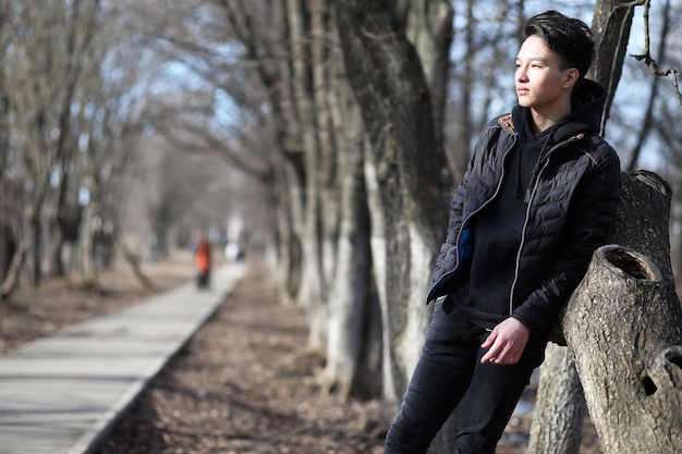 Rapaz asiático adolescente no clima frio da estação da natureza