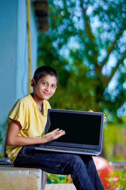 Rapaz asiático usando o computador portátil para o estudo online do ensino doméstico durante a quarentena em casa. ensino doméstico, estudo online, quarentena doméstica, aprendizado online, vírus corona ou conceito de tecnologia educacional