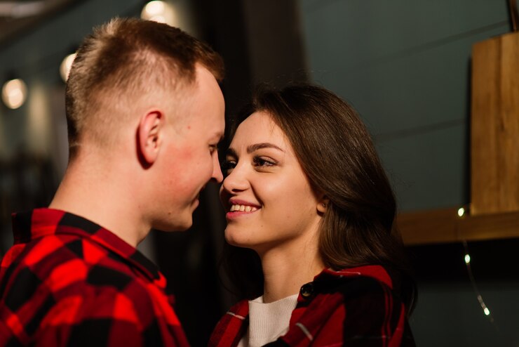 Foto rapaz beijando sua adorável namorada, sentindo-se feliz enquanto celebra as férias de inverno