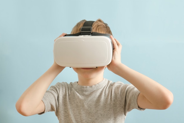 Rapaz com óculos de realidade virtual. Fundo azul