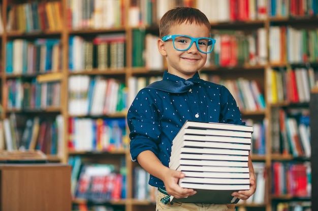 Rapaz com óculos e pilha de livros