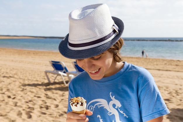 Rapaz comendo sorvete na praia