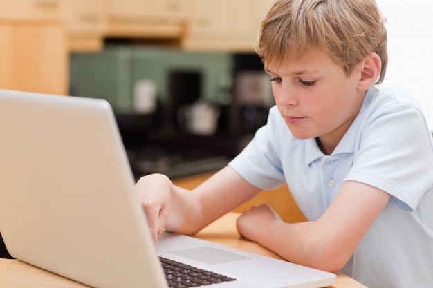 Rapaz focado usando um laptop