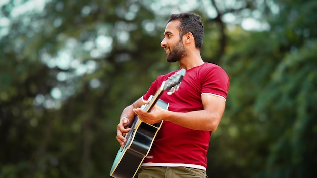 Rapaz guitarrista tocando imagem de guitarra ao ar livre