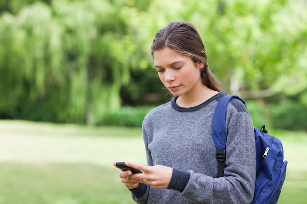 Rapaz jovem e calma usando seu celular para enviar um texto