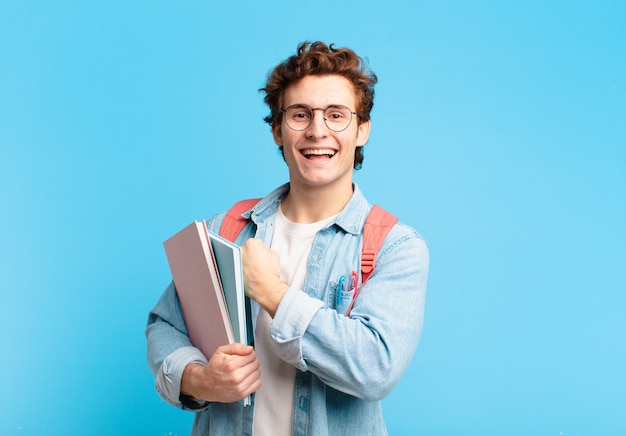 Foto rapaz jovem estudante sentindo-se feliz, positivo e bem-sucedido, motivado para enfrentar um desafio ou comemorar bons resultados