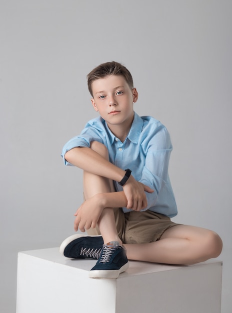 Rapaz posando com uma camisa da moda e camisetas no estúdio