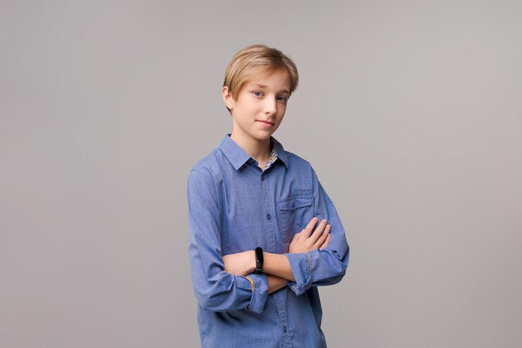 Foto rapaz rindo em camisa azul casual posando isolado na parede cinza clara