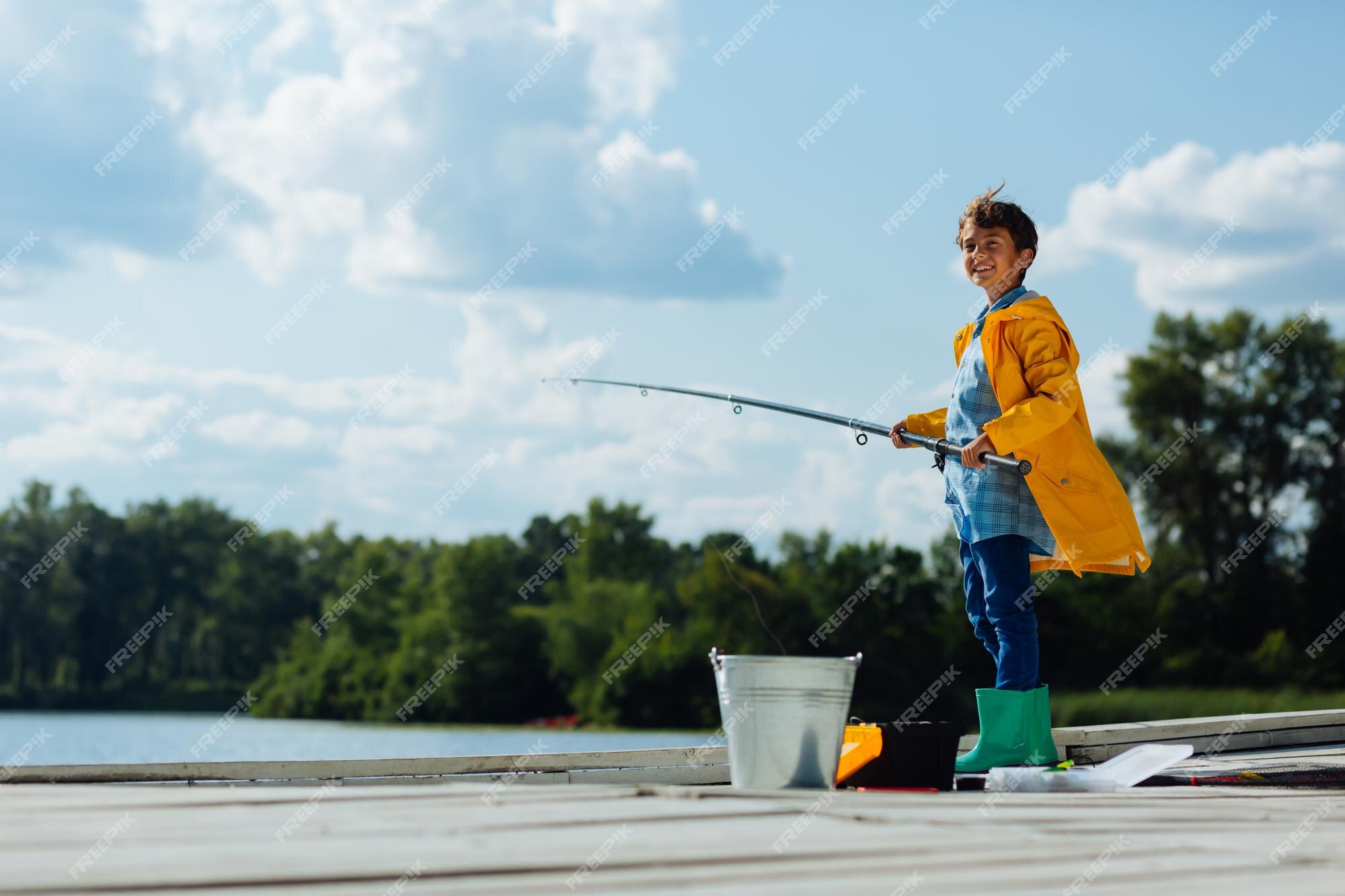 Rapaz sorrindo enquanto pesca em bom dia ensolarado | Foto Premium