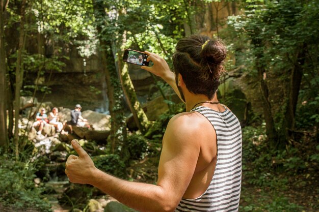 Foto rapaz tira uma selfie na floresta, imagem a cores