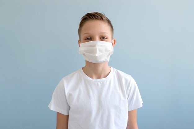 Foto rapaz usando máscara médica dentro de casa