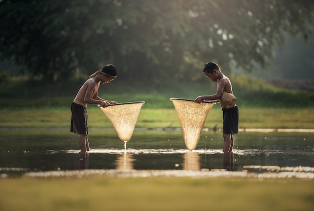 Rapazes da ásia pescando no lago