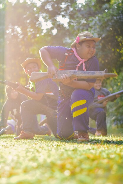 Rapazes de escola sorridente a brincar no campo.