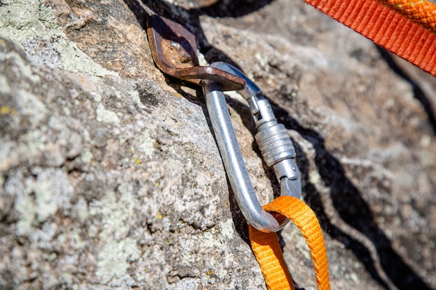 Rappel por la roca del tronco con cuerdas y mosquetón en la montaña