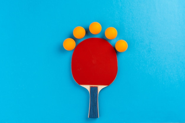 Foto raqueta de ping pong y pelota en azul