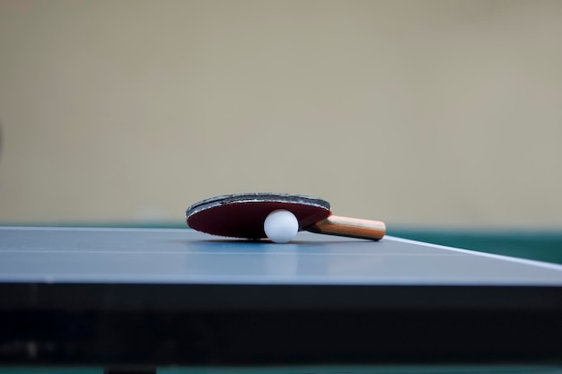 Foto raqueta de tenis de mesa y pelota en la mesa