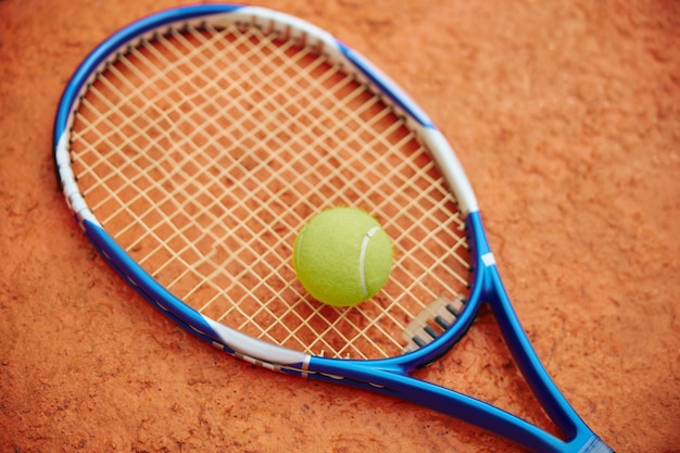 Raqueta de tenis con pelota al aire libre en un campo de color