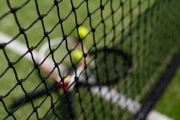 Una raqueta de tenis y una pelota de tenis nueva en una cancha de tenis recién pintada